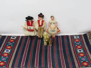 dolls (international), handwoven mat, and alabaster jade good luck elephant