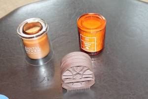 lot 59 image: Set of 2 Scented Candles with Decorative Coasters - Santal Woods & Pumpkin Woods