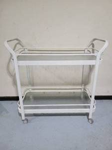 lot 130 image: A two level white metal and glass Wheeled Serving Cart.