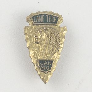 lot 217 image: Lane Tech High School, Indian Portrait And Arrowhead (Jan 40) Yellow Base Metal Lapel Pin. Green Enamel Background On Lettering