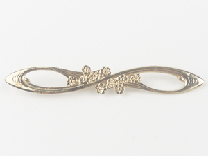 lot 240 image: Floral Figure Eight Gold Tone Base Metal Brooch .