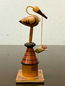 lot 214 image: Very Cool Vintage Carved Wood Stork on Rooftop Holding Baby