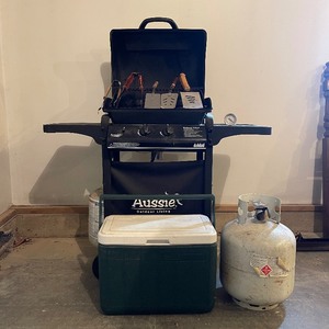 lot 88 image: Aussie Bushman Gas Grille with Extra Tank and Coleman Cooler, Three Metal Spatula and Two Tongs
