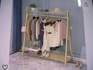 Gold colored clothes rack. Free sta...
