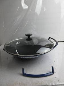 lot 76 image: Le Creuset Enameled Cast-Iron 14-14-Inch Wok with Glass Lid, Cobalt Blue  1 HANDLE BROKEN, LID IS BENT , CLOSES, NEW