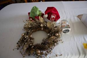 lot 94 image: Holiday Decor Set Wreath, Santa Hat, Elf Hat, and Gingerbread House Ornament