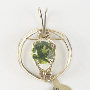 lot 256 image: New Old Stock Handcrafted large wrapped Round Brilliant Cut Peridot gold filled wire pendant (no chain), set with peridot. Replacement value $400