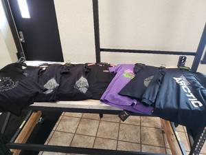 lot 241 image: Lot of Womens Size Medium - FXR Endeavor Merino base layer Black  Pink and 7 t-shirts mostly black and one purple (5 Artic Cat & 2 Motorfist)