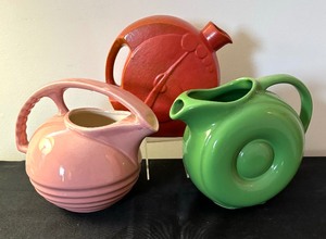 lot 116 image: Art Deco Vintage Dusty Rose Glazed Overhead Ridged Handle Porcelain Pitcher and Two Vintage Art Deco Juice Pitchers