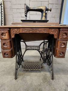 lot 2 image: Antique Singer Sewing Machine Table with foot operated Crank and Detailed Carvings