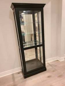 lot 9 image: Showcase your collectibles in this Howard Miller CurioDisplay Cabinet.
