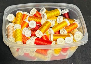 lot 148 image: Bin of Assorted Red and Orange Thread Spools
