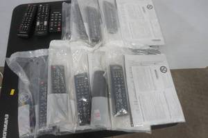 lot 127 image: lot of remotes and manuals. Mostly Samsung, some Insignia. NEW and LIKE NEW