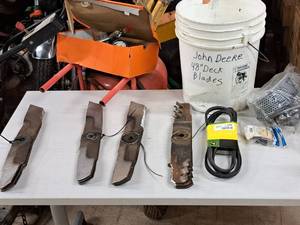 lot 253 image: Assorted John Deere 48 Deck Mower Blades, Belts and Carbeuretor Parts