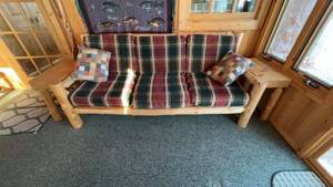 Rustic Log Cabin Couch with Plaid Cushions and Side Table