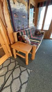 Rustic Log Cabin Couch with Plaid Cushions and Side Table