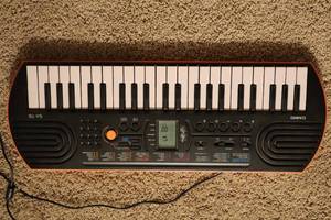 lot 26 image: Casio SA-76 Mini Portable Keyboard Piano Organ, The Older Beginner Piano Course Book