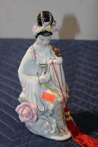 lot 511 image: Elegant Porcelain Figurine of a Woman with Flowers and Musical Instrument