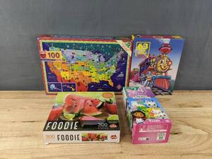 lot 199C image: 4 Brand New Kids Puzzles - Gabbys Dollhouse (24 pc) Eeboo This Land is Your Land (100 pc), Hoyle Train (63 pc), and Goliath Foodie Watermelon (300 pc) B