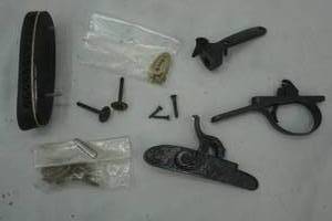 lot 96 image: gun butt plate, and other gun parts