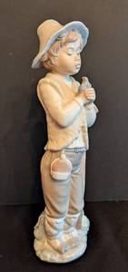 lot 23 image: Lladro Nao Porcelain Boy with Bird Figurine