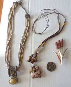 lot 10 image: Multi strand necklace with sterling pendant and closure that just needs some cleaning, native horse necklace, horse coin that is from studden saddles and a cattail pin