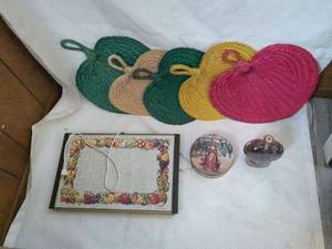 lot 54 image: Collection of 5 Woven Fruit-Shaped Trivets, Decorative Book, and Glass Bottle