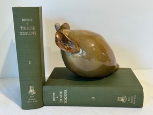 lot 180 image: Vintage Home Decor Display w TRADE TOKENS Books By George C Williamson & Ceramic Pear