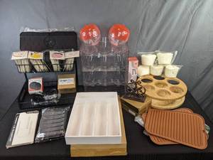 lot 220 image: Large Assortment of KitchenOrganization Items Compressed Sponges, Silicone Cup Boot for Tumblers, Cast Iron Napkin Holder, Coffee Storage Items, Stackable Bottle Storage Shelves and More