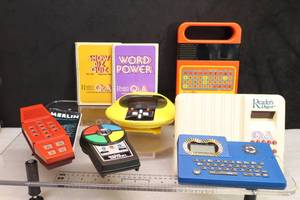 lot 57 image: Vintage Handheld Toy GamesPocket Simon, PAC Man, Wheel of Fortune, Readers Digest Q & A wBooks, Merlin, Speak & Spell