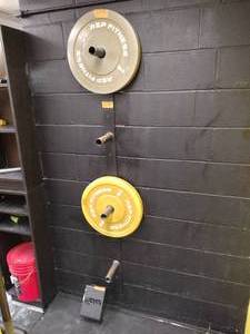 lot 28 image: Weighted plate rack and barbell wall rack