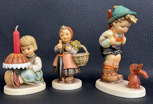 lot 180C image: Three Collectible Hummels - Sensitive Hunter, Birthday Cake and On Holiday -Girl with Umbrella and Basket