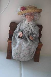 lot 539 image: Charming Decorative Doll with Straw Hat and Floral Dress on Miniature Bench