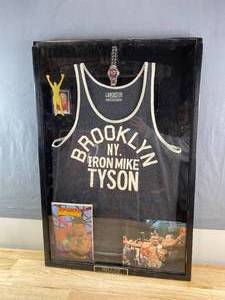 lot 8 image: Framed Mike Tyson Collage with Watch, Iron Mike Tyson Boxing Tank Top, Sports Superstars Comic and More K