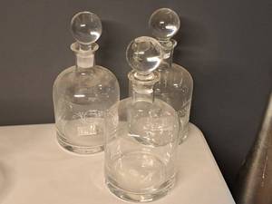 lot 995 image: Lot of (3) 11-12 Clear Glass Round Wine Decanters with Topper - Merlot, Pinot Noir and Cabernet