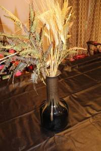 lot 69 image: Black Ceramic Vase with Artificial Fern and Wheat Stalk Arrangement