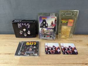 lot 104 image: Collection of KISS Memorabilia Psycho Gold Card, 2001 Daily Trivia Calendar, KISS City Coasters, Action Sterling 40 Marlin Diecast Car, and Playstation Pinball Game 2001