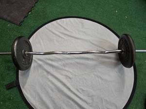 lot 40 image: Lot of a pair of One-inch 25LB Plates with a curl bar ( Used)