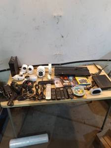 lot 87 image: Electronics Lot with Security Cameras, Remote Controls, and DVDs