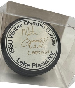 lot 283 image: 1980 LAKE PLACID OLYMPICS HOCKEY PUCK  SIGNED BY USA CAPTAIN MIKE ERUZIOE