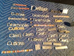 lot 218 image: lot of auto emblems, metal tire air caps and shifter top