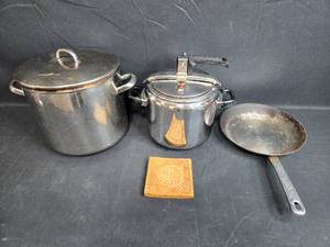 lot 28 image: Stainless Steel Pot, Pressure Cooker, Skillet, and Decorative Trivet