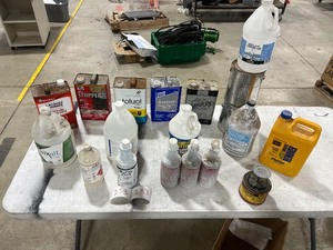 TABLE FULL OF CHEMICALS, LACQUER THINNER, STRIPPER, TOLUOL, ACETONE, ISO, BURNING ALCOHOL, BURNOUT, SPRAY GUN PARTS CLEANER, NOX SMOKE, WINDOW CLEANER, ADHESIVE REMOVER, & PLUNGER CAN