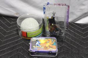 lot 57 image: Lot of 3 Collectibles Stress Ball, Maleficent Action Figure, and Pokemon Mini Lunch Box