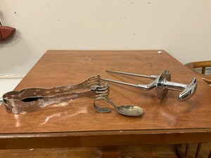 lot 58 image: Lot of silverplate spoon, unmarked serving tong and carving piece.