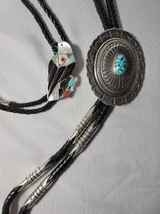lot 92 image: 2 Bolos  with Leather Strap.   One with turquoise center and one with a bird design