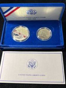 lot 86 image: 1986 US LIBERTY SILVER DOLLAR WITH CLAD HALF DOLLAR