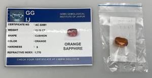 lot 54 image: GGIJ 13.05 Ct. (LAB CREATED) Cushion Cut Orange Sapphire With Card