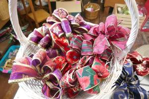 Large wicker basket full of colorful beautiful handmade bows