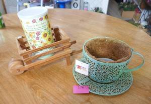 Metal coffee cup planter, wheelbarrow and can of flower seeds